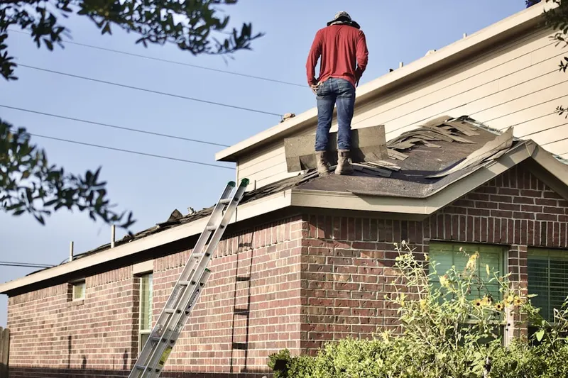 Professional roofer working on a residential roof in Flint Town